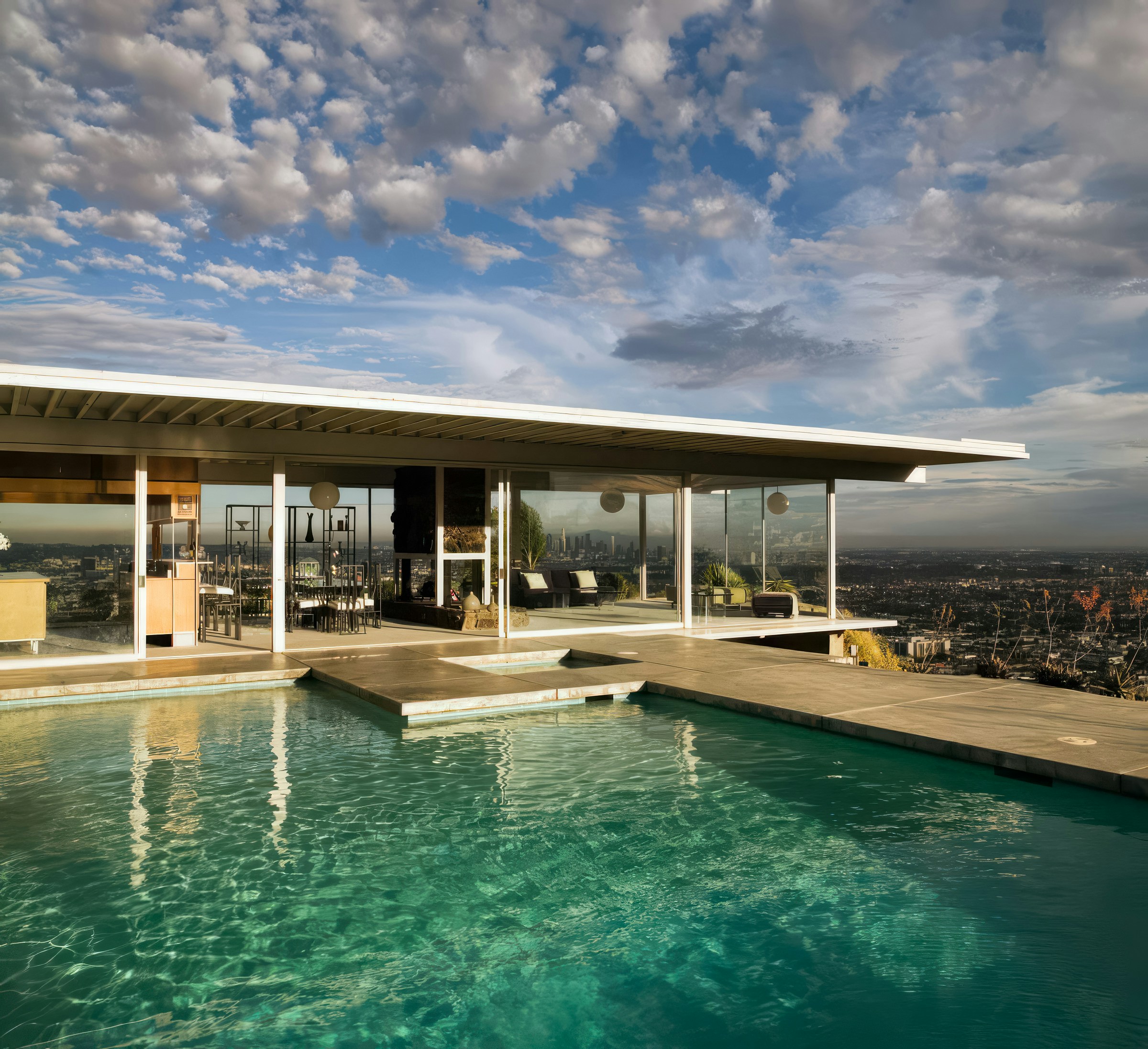 A beautiful modern home with large windows and a well-lit interior, overlooking Los Angeles.